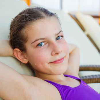 In aquapark. Smiling beautiful girl relaxing in armchair.