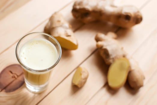 fresh organic healthy ginger shot juice and root