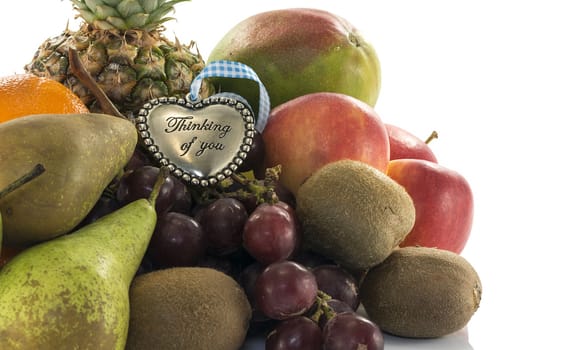 fruit as oranges pineapple grapes and kiwi isolated on white with thinking of you plate