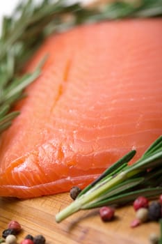 Piece fresh salmon with spices, closeup on wooden background