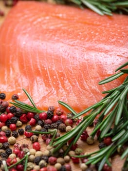 Piece fresh salmon with spices, closeup on wooden background