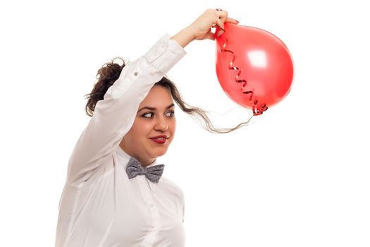 confident woman playing with balloon on white background