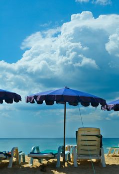 Beach chairs and umbrella at a tropical resort.