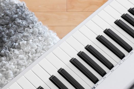 Close-up of electric piano keys and chair.