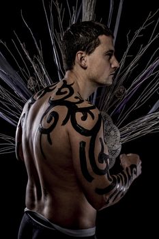 Art. Young attractive retro model in old-fashioned wild clothing Tribe. Tattoo. Native savage man