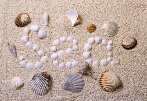 Title "Sea" from shells with coral sand as background