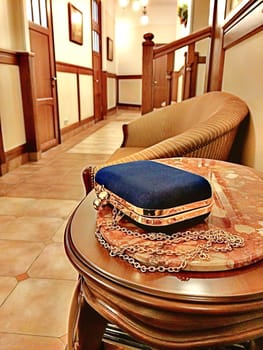 Blue handbag lying on a table, office interior grunge toning