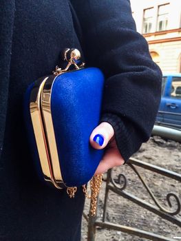 Woman holding a blue handbag in her hand, closeup