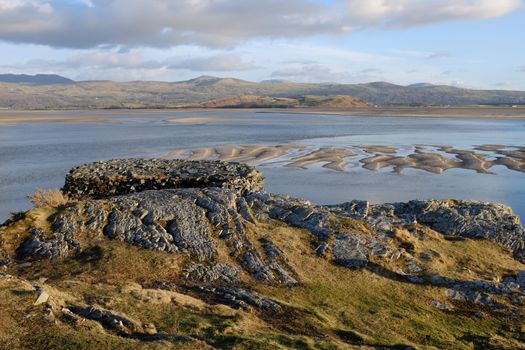 A flat topped view point looks out over an estuary and distant mountain range.