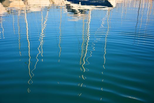 boat masts reflected in water