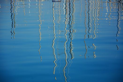 boat masts reflected in water