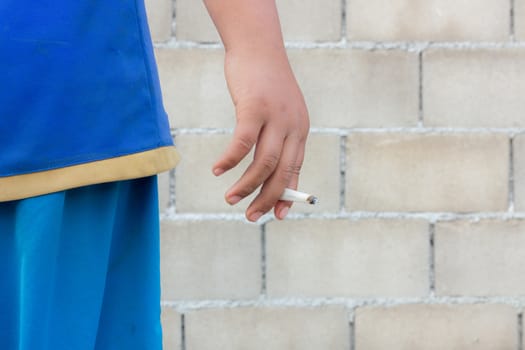 a cigarette is in a child's hand