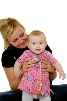 Mother is looking down on her sweet smiling baby. Taken on a white background.