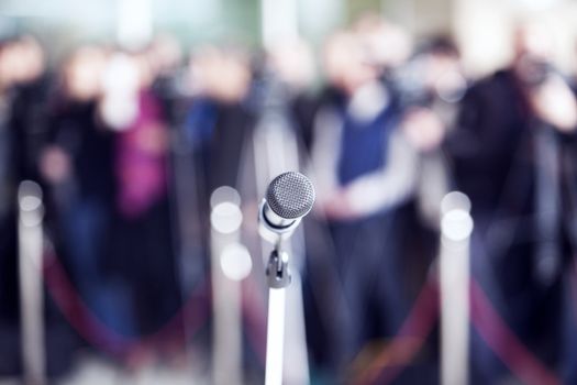 Microphone in focus against blurred audience