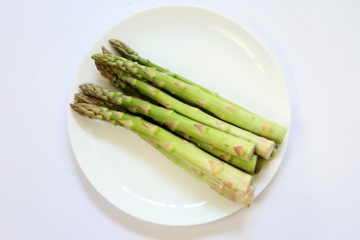 Green vegetable Asparagus bundle in a white plate