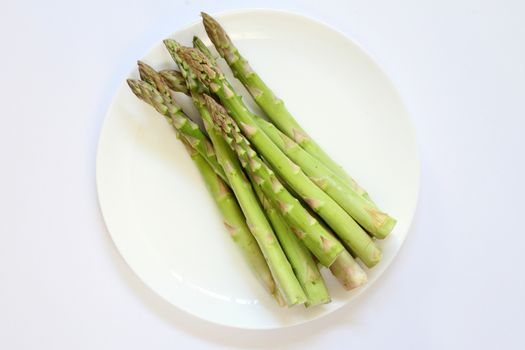 Green vegetable Asparagus bundle in a white plate