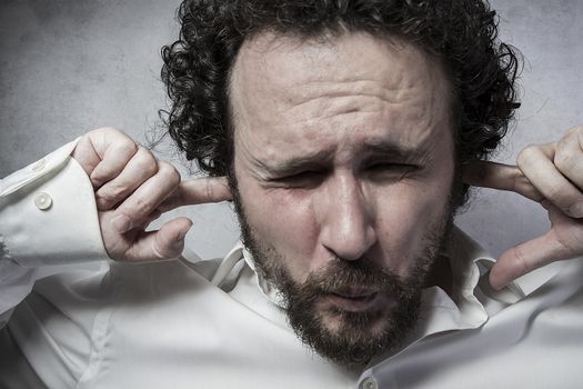 Businessman covering his ears, man in white shirt with funny expressions