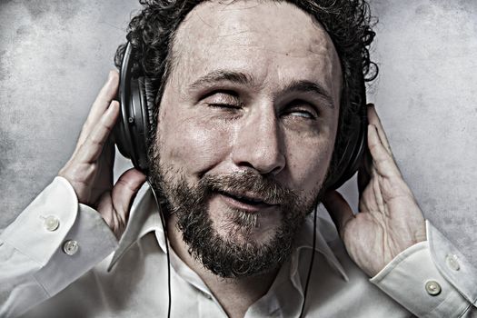 listening and enjoying music with headphones, man in white shirt with funny expressions