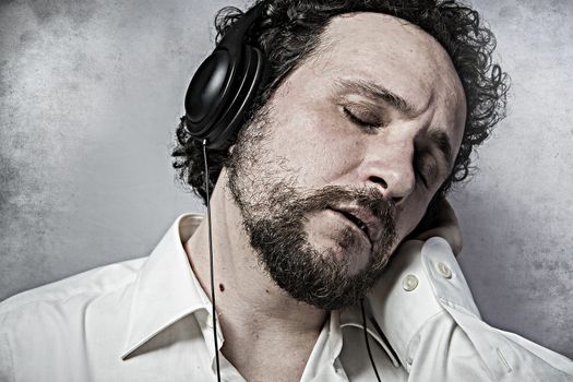 Joy, listening and enjoying music with headphones, man in white shirt with funny expressions