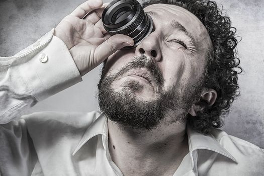 Businessman looking through a lens, man in white shirt with funny expressions