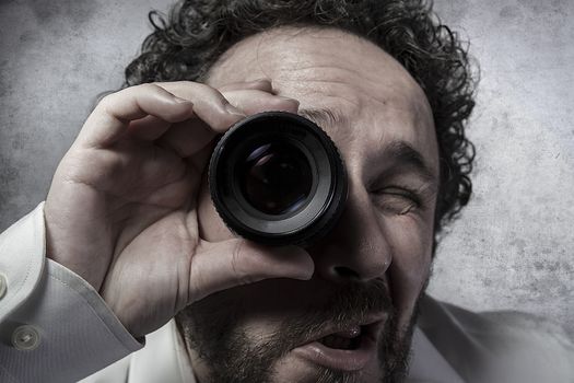 Businessman looking through a lens, man in white shirt with funny expressions