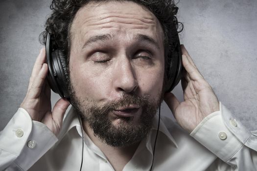 Lifestyle, listening and enjoying music with headphones, man in white shirt with funny expressions