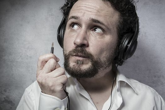 Jack, listening and enjoying music with headphones, man in white shirt with funny expressions