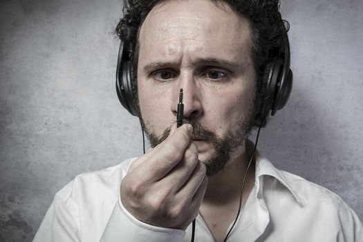 listening and enjoying music with headphones, man in white shirt with funny expressions