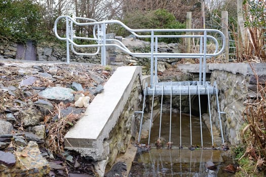 A metal platform and grill built over a small stream as a flood prevention measure.