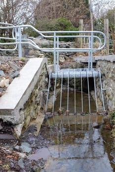 A metal platform and grill built over a small stream as a flood prevention measure.