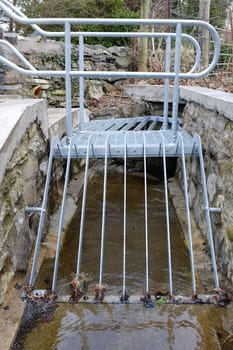 A metal platform and grill built over a small stream as a flood prevention measure.