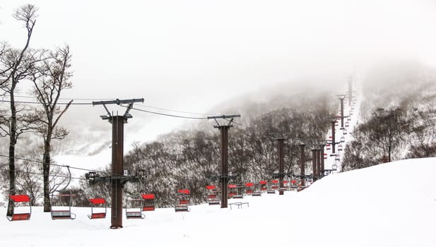 Ski chair lift with skiers on mountain