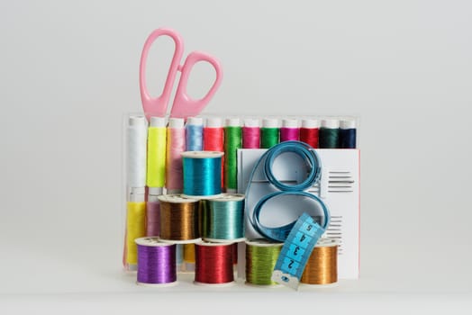 Coils with color strings of various color, sewing needles, scissors and sartorial centimeter