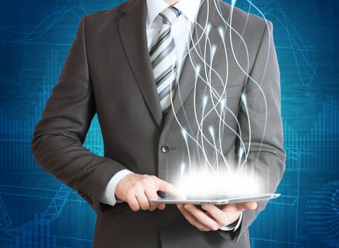 Businessman in a suit holding a tablet computer. Rays emitted from the tablet
