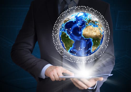 Man in suit holding tablet pc and earth in hand. Communication around the earth. The concept of communication