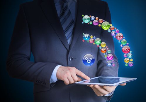 Businessman in a suit holding a tablet in his hands. Above the screen tablet application icons in the form of RSS icon