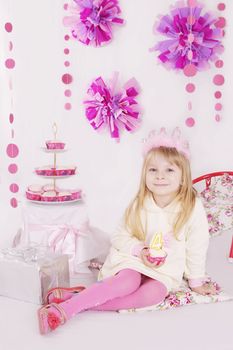 Little girl with cake at pink decoration birthday party