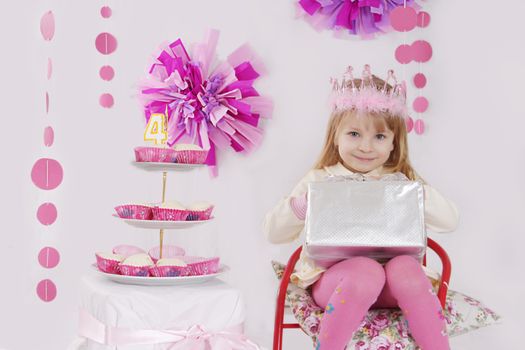 Little girl with present at pink decoration birthday party