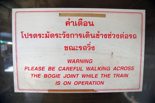 Warning information plate at railway station Thailand