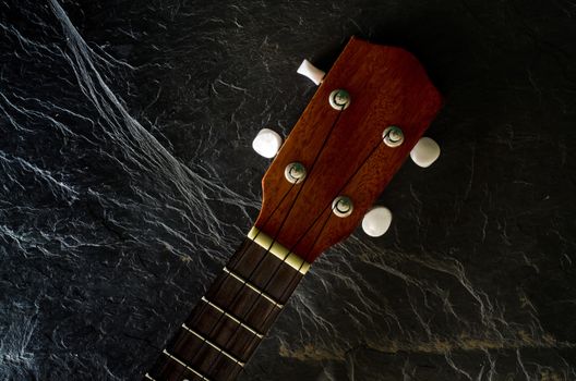 ukulele against a stone  background.