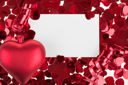 small red confetti and big hearts on white background with card for valentine message