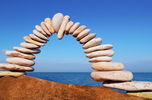 Arch of white pebbles in the balance on the seacoast