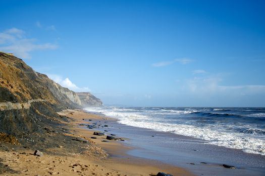 Charmouth beach rough sea and Golden Cap Dorset England