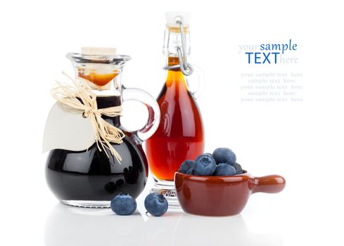 blueberry syrup in glass bottle or mixture, with heart label. on white background.