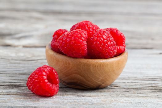 bowl of raspberries on wooden table