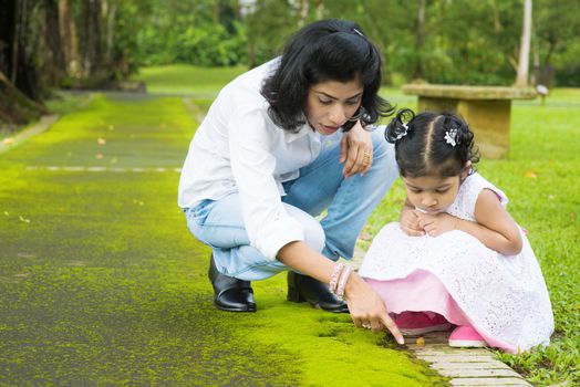 Indian family outdoor activity. Candid portrait of mother and daughter exploring on nature, outdoors education.