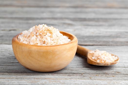 Pink salt  in the wooden bowl, on wooden board