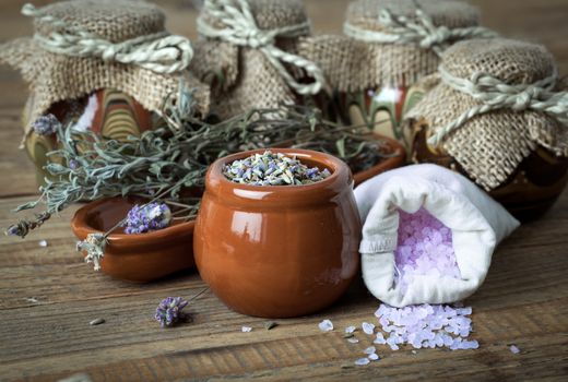 dry lavender flowers with bath salt, on wooden background.