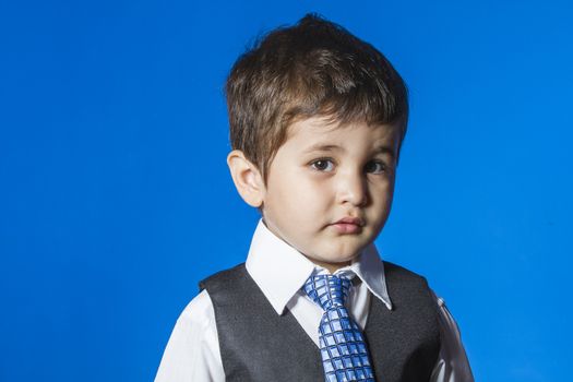 Leader, cute little boy portrait over blue chroma background