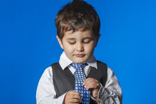 Leader, cute little boy portrait over blue chroma background